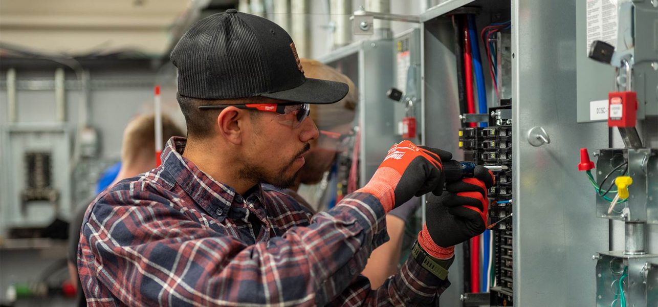 Electrical Trades Center Apprentice training on an electrical panel